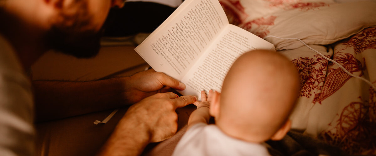 ayna photographe papa lit un livre à bébé